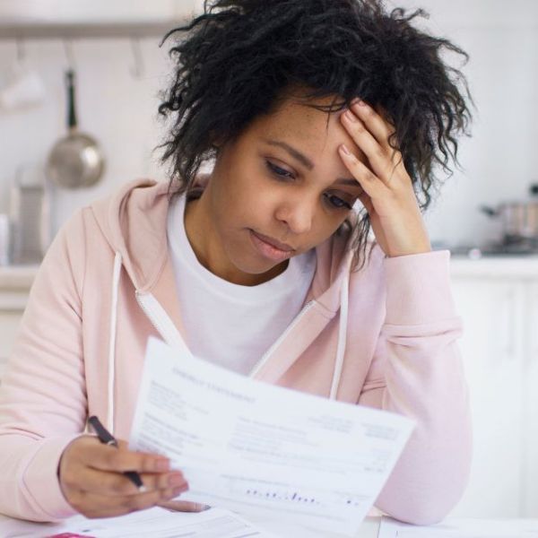 Single young african american female with many debts feeling stressed, calculating finances.