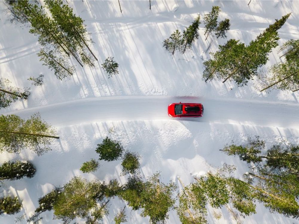 Car driving down a road covered in snow