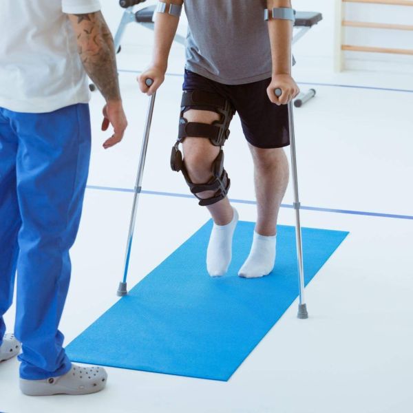 a man with a broken leg is walking with a crutch