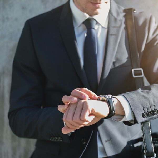 Stylish man wearing suit looks at watch