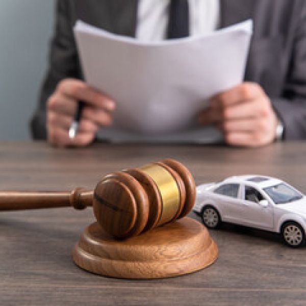 Judge's gavel and toy car on table, representing auto law or car accident legal matters.