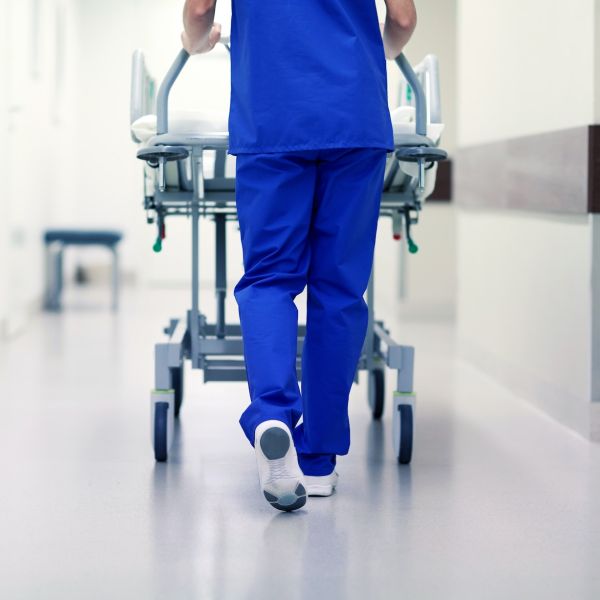 nurse carrying hospital gurney to emergency room
