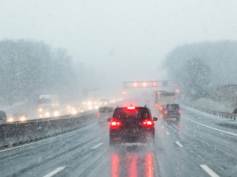 cars driving down a snowy highway