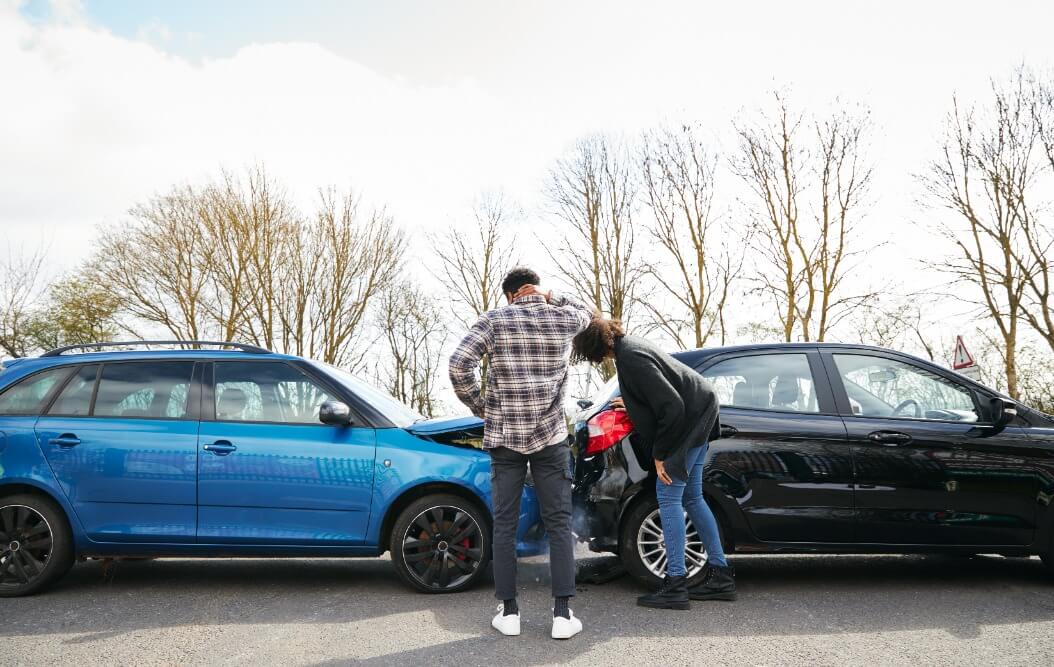 man and a woman looking at a rear end accident