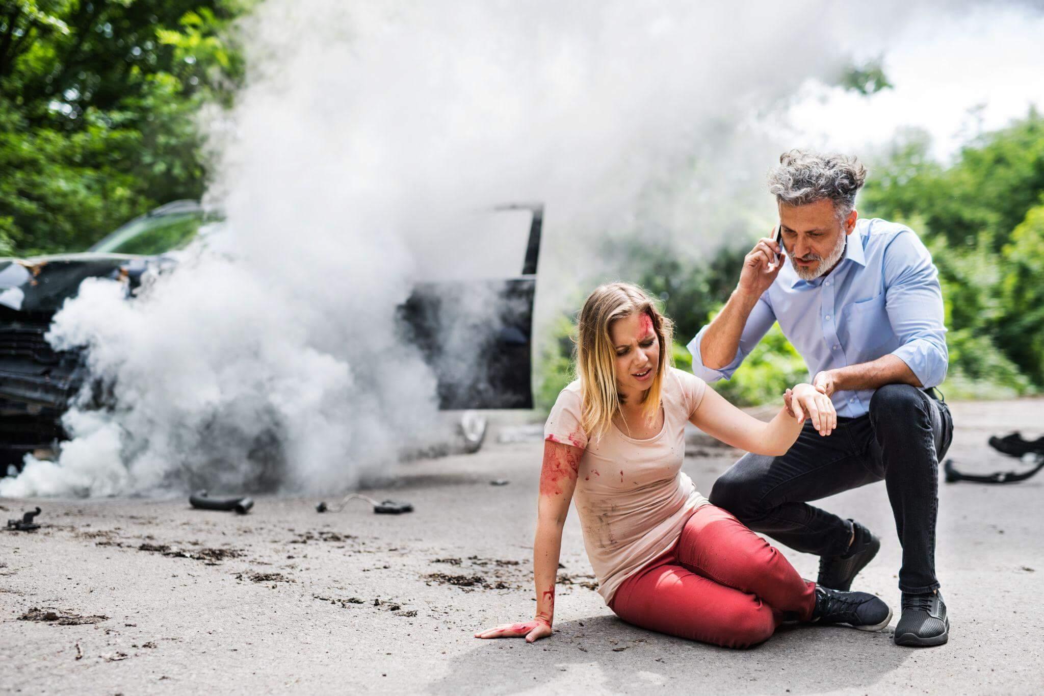 a man kneeling down next to a woman on the ground