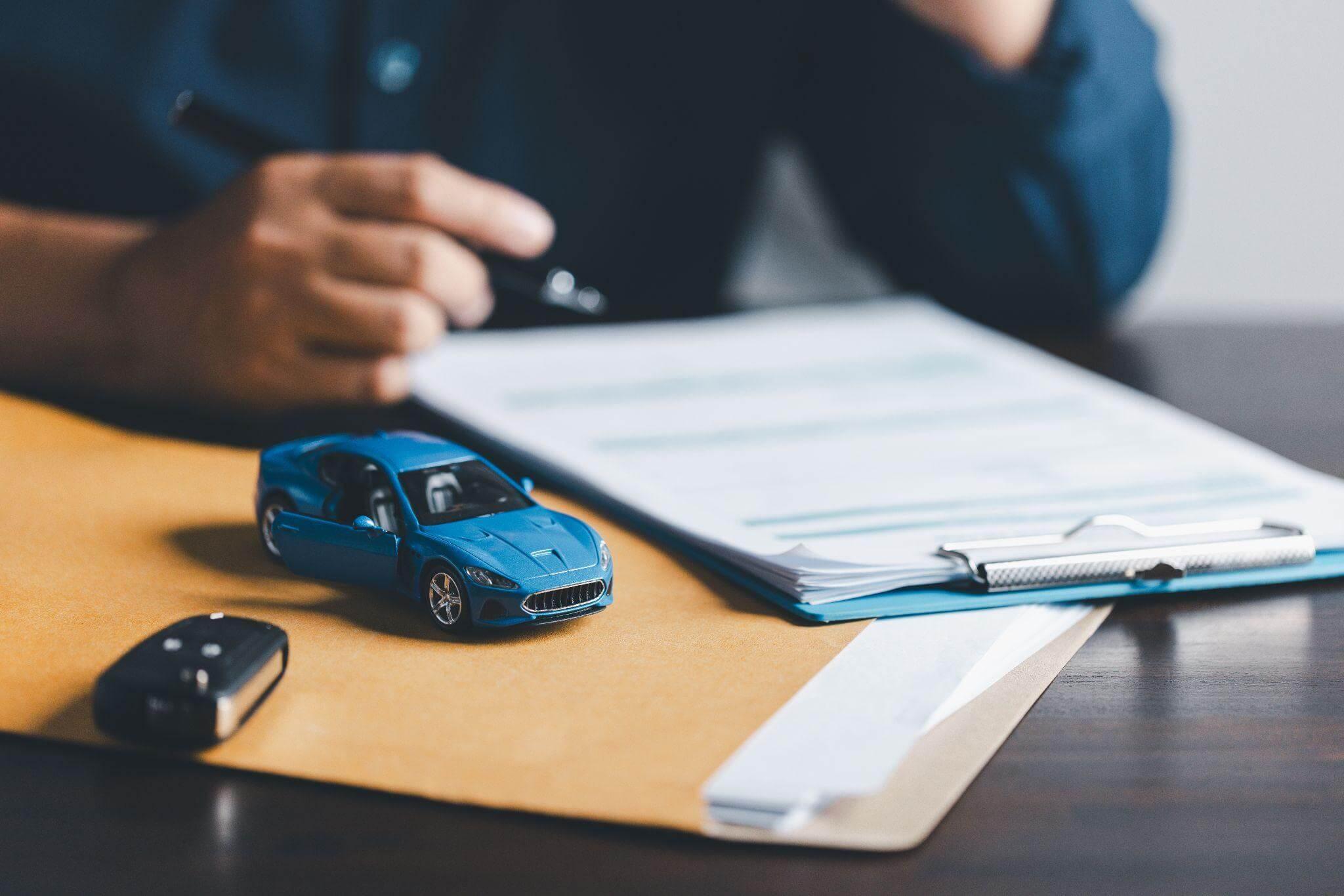 a toy car sitting on top of a desk next to a notepad