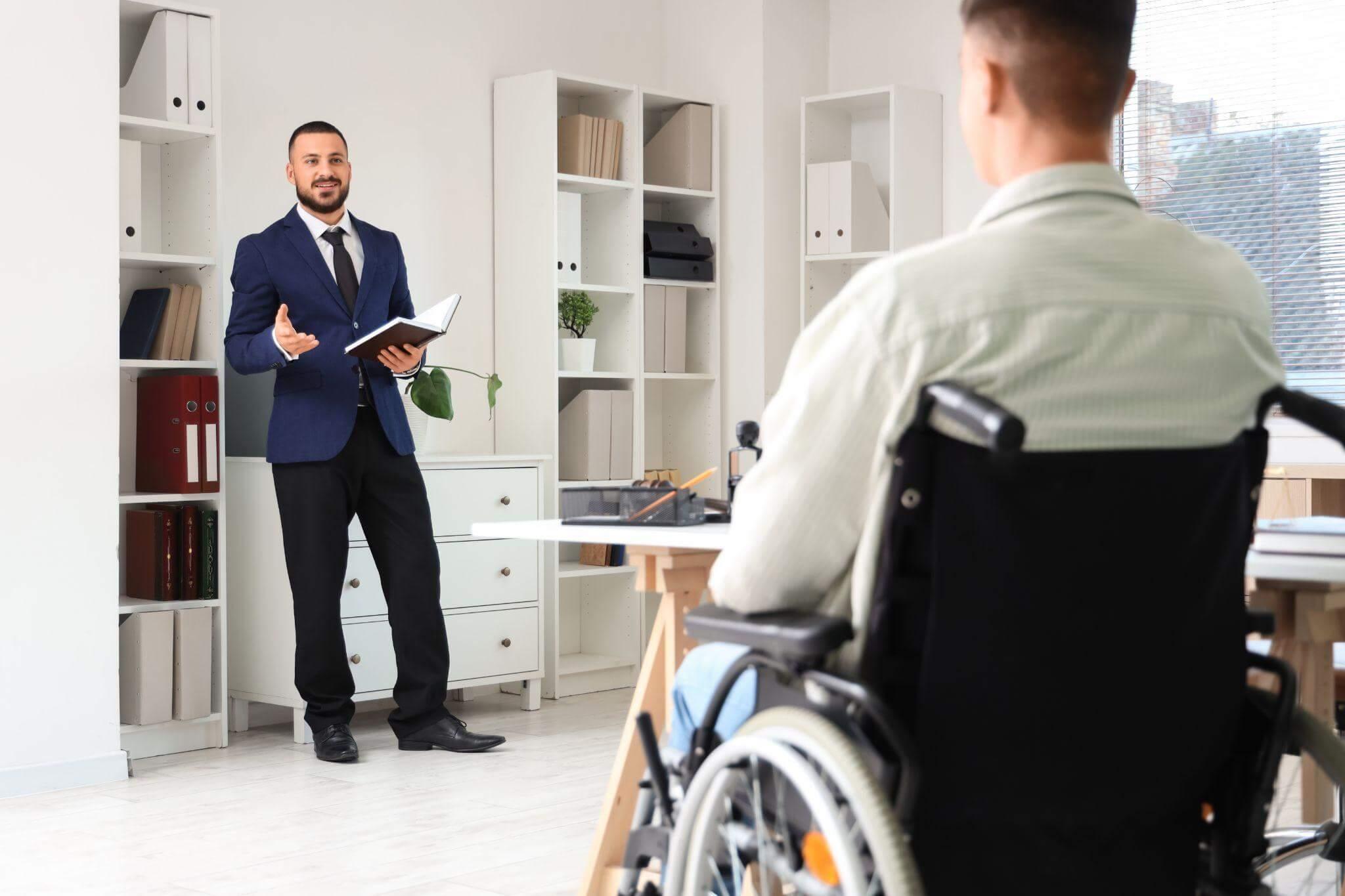 a man in a suit standing next to a man in a wheel chair