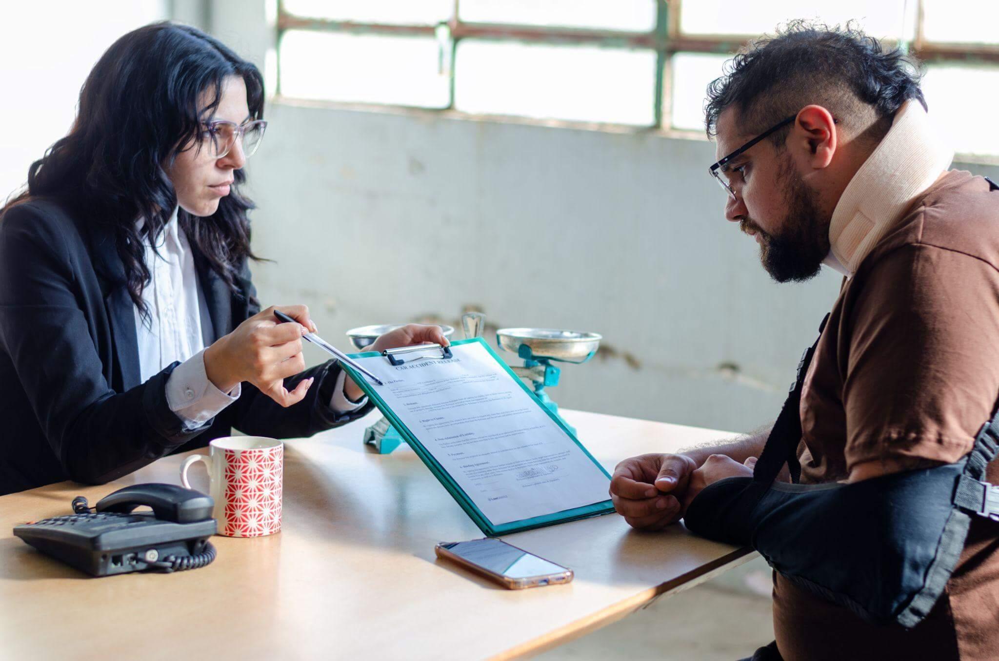a man and woman sitting at a table with a clipboard