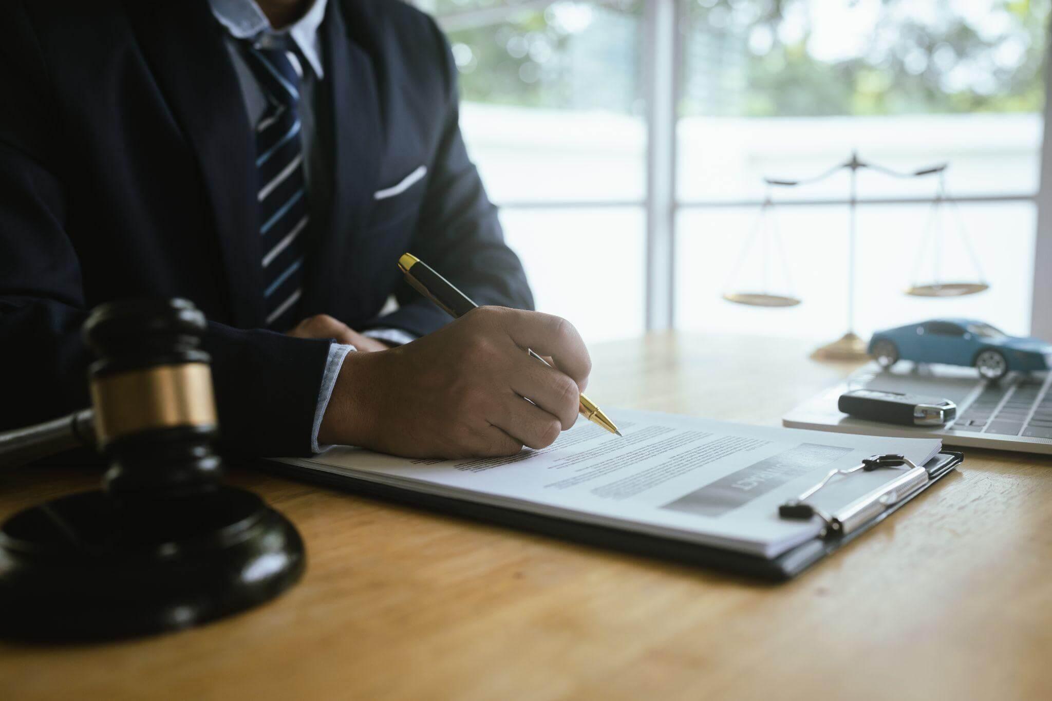 a man sitting at a desk writing on a piece of paper