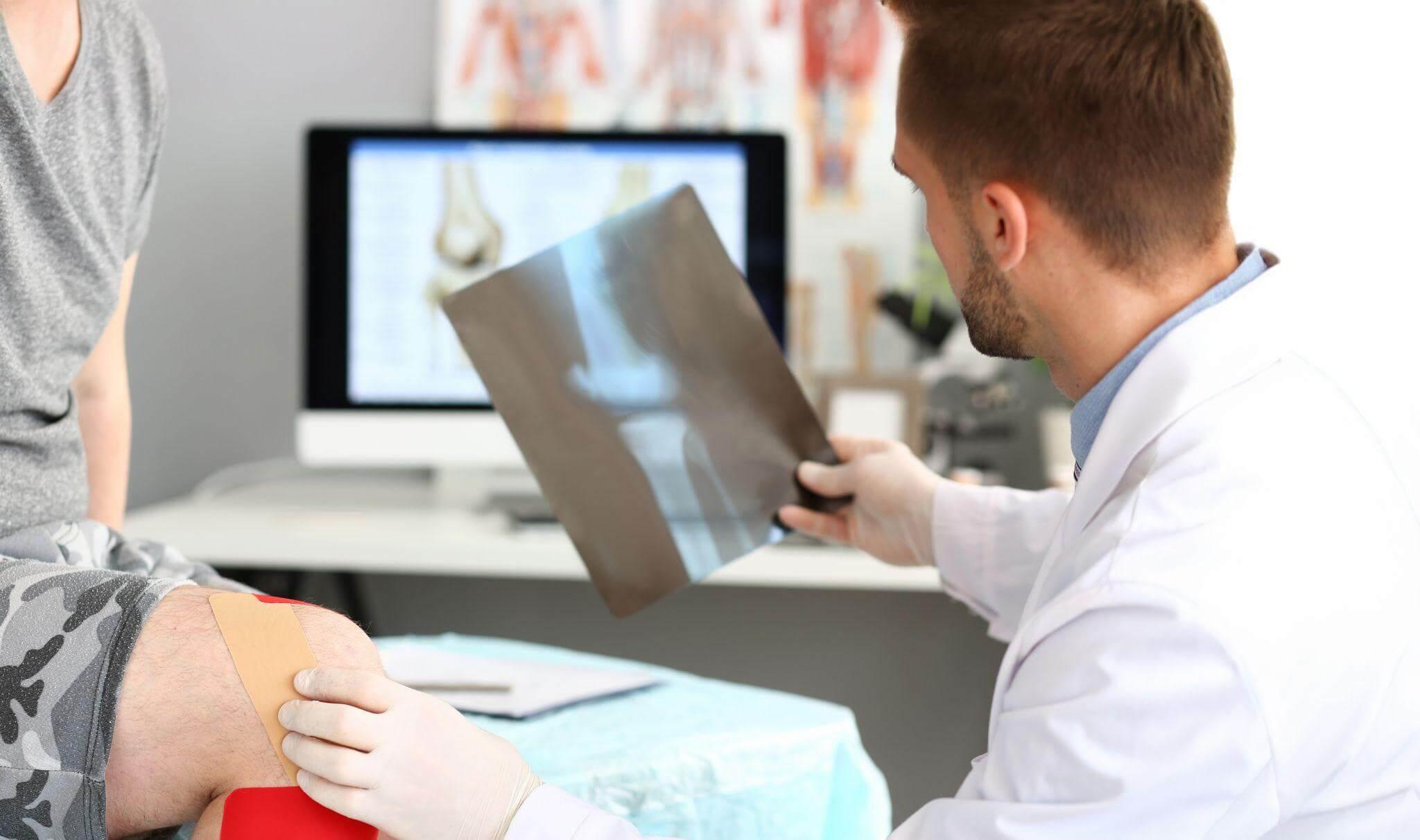 a man with a cast on his leg is being examined by a doctor