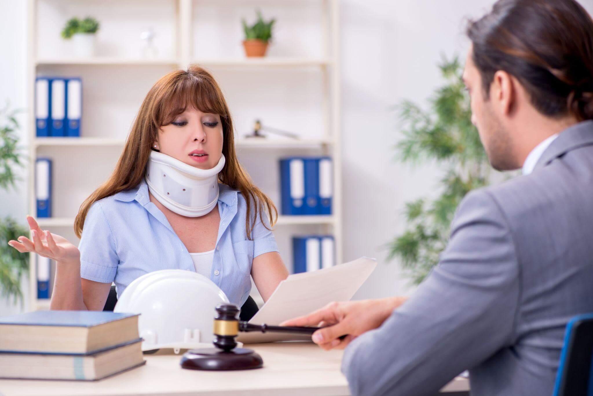a woman with a neck brace sitting at a desk