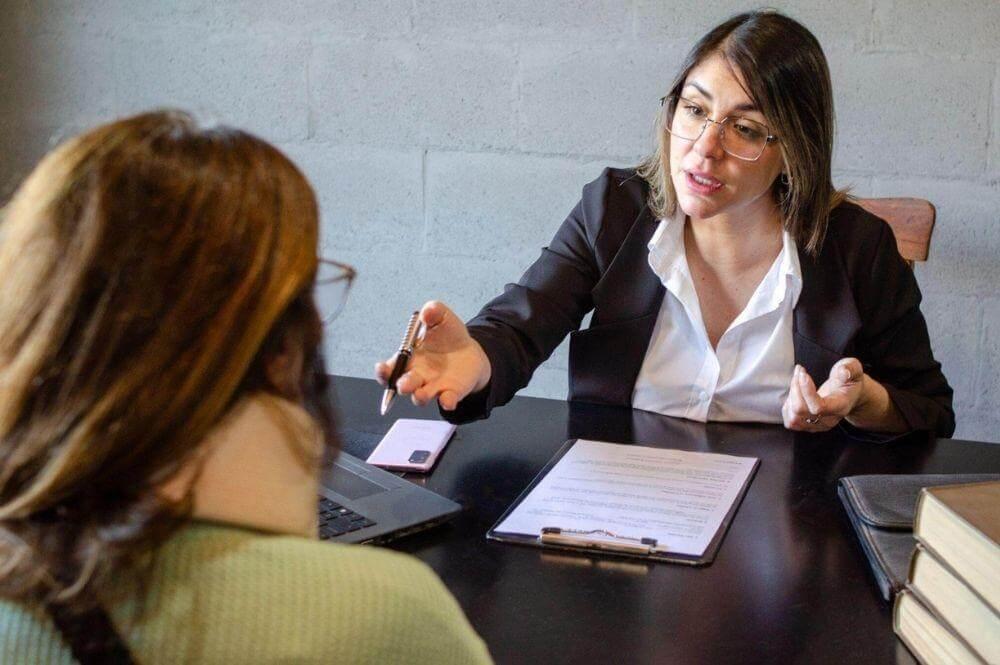 Two women discussing a client review of Uber accident settlement